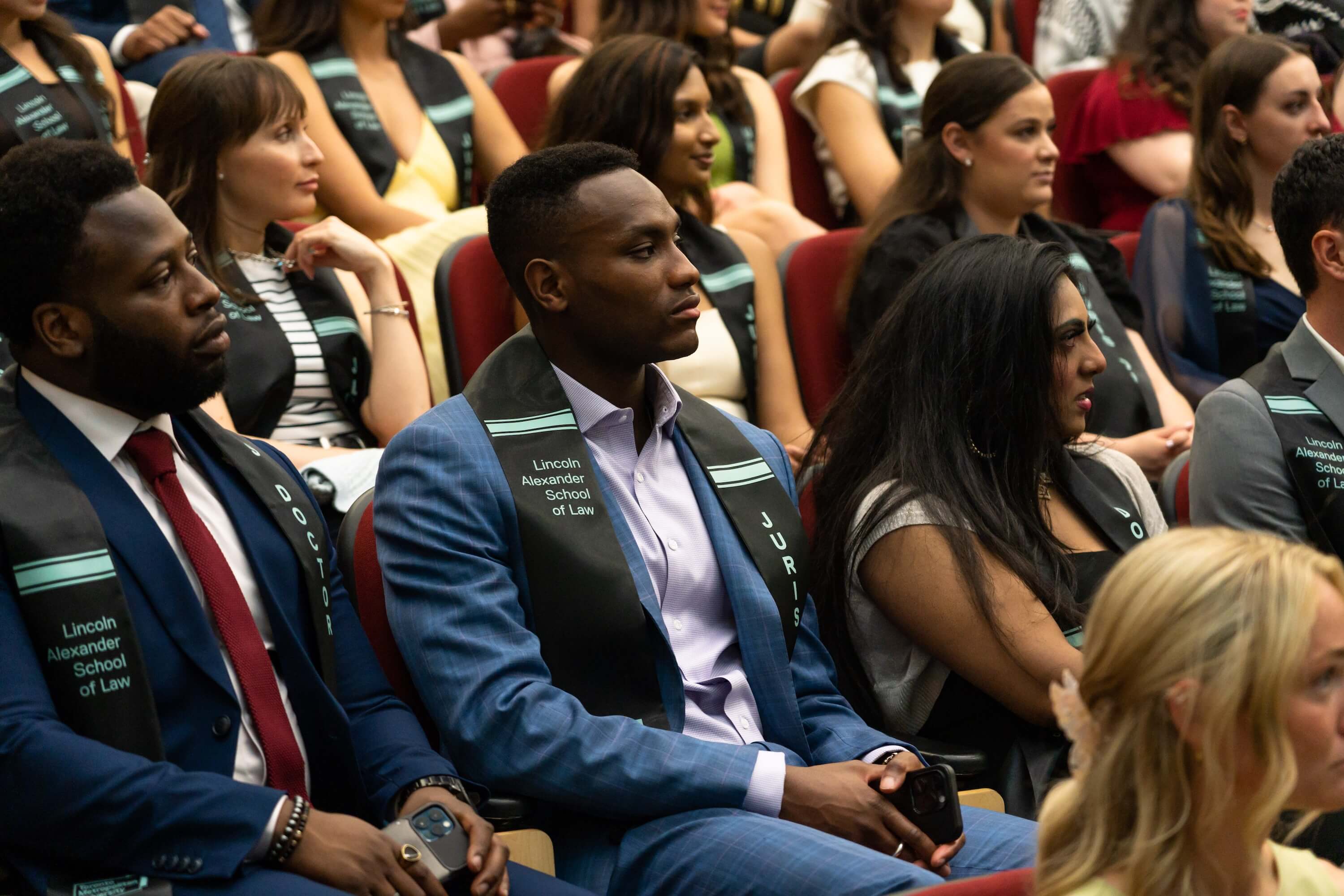 Graduates sitting in an auditorium. 