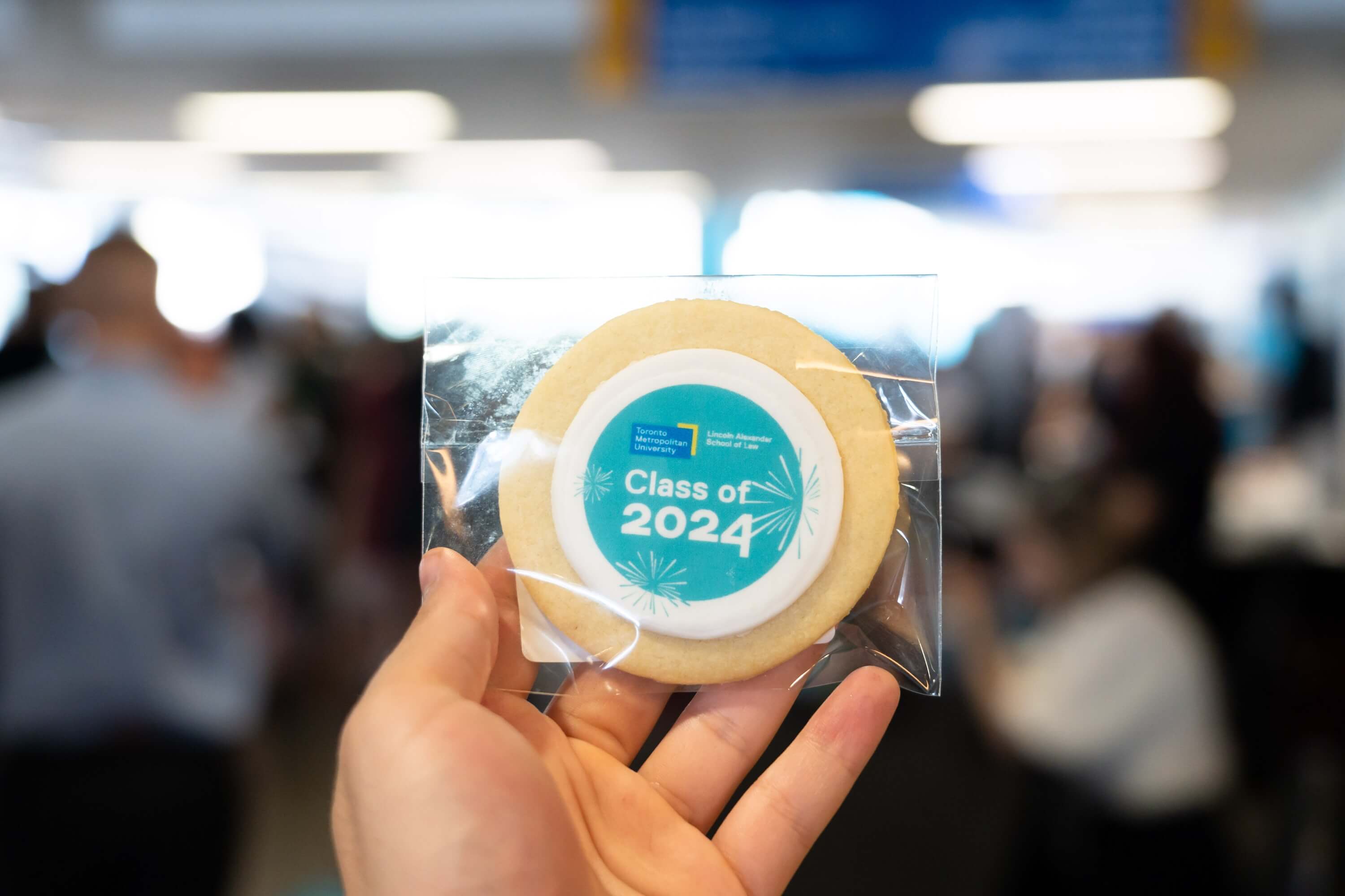 A hand holding a "Class of 2024" cookie.