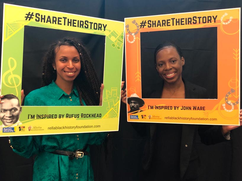 From left: Ebyan Bihi and Madison Henry holding square cardboard cutouts