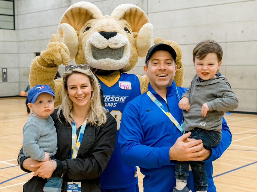 Eggy the Ram standing behind a family of four