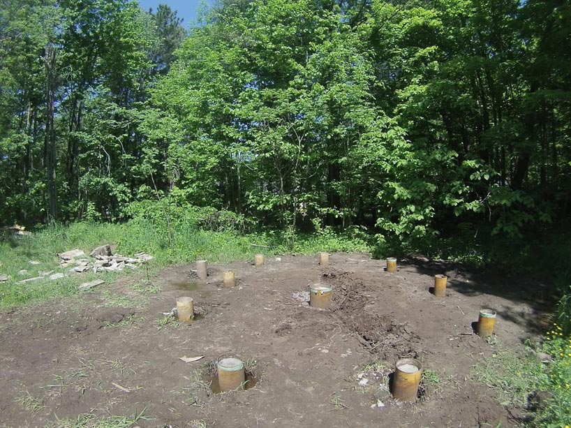 Stumps of wood in dirt in a clearing in the woods