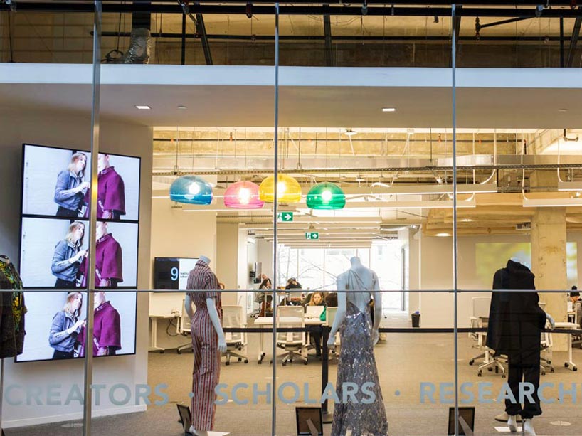 Inside the research space, mannequins in outfits, coloured lights and students working at desks