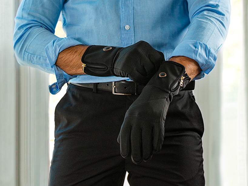 A man in business attire puts on a pair of black Smart Gloves