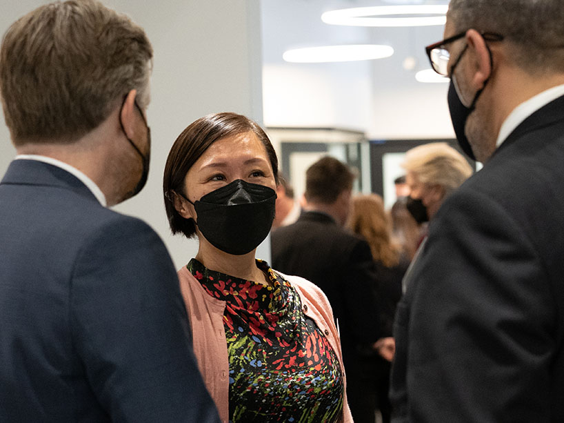 Darcy Rollins, Angel Lam and Mohamed Lachemi speaking to each other with masks on.