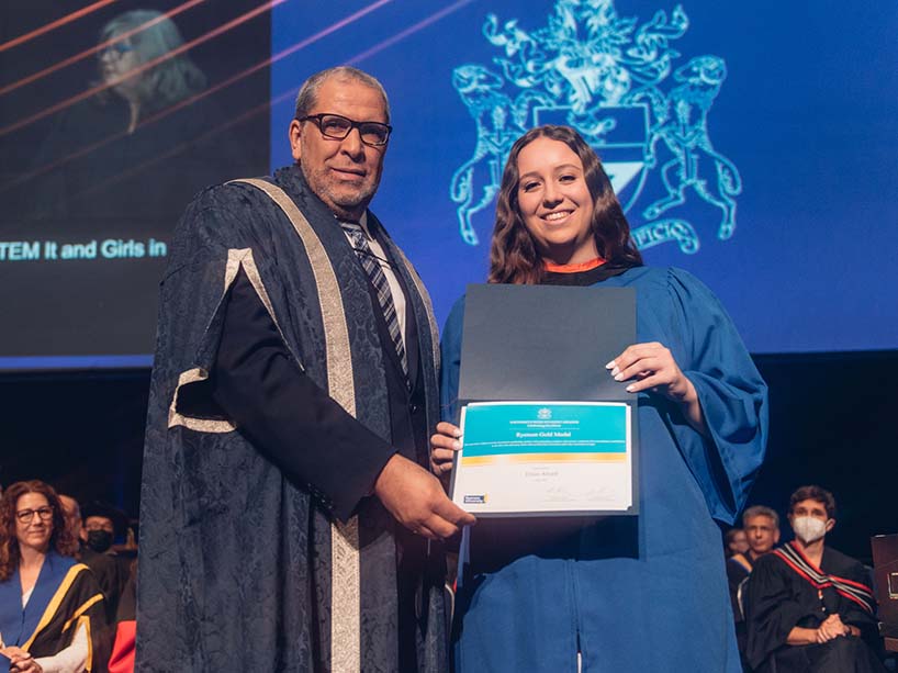 Erica Attard holding her Gold Medal award with President Mohamed Lachemi.