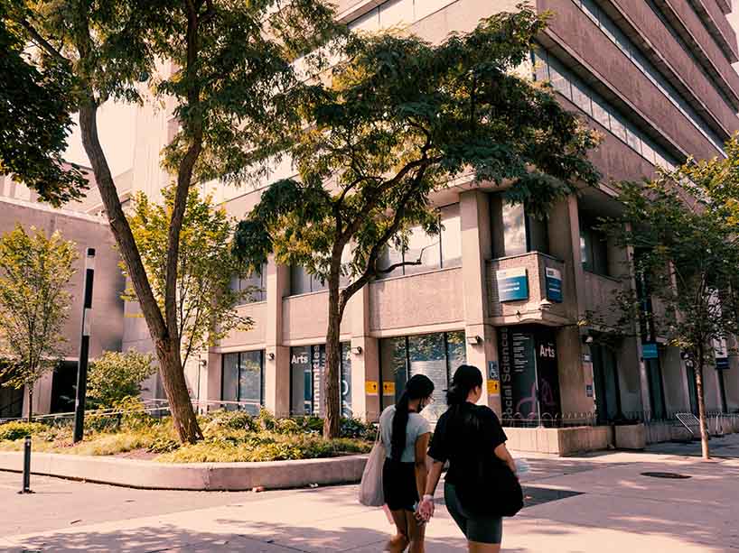 Two students walking outside on the university campus.