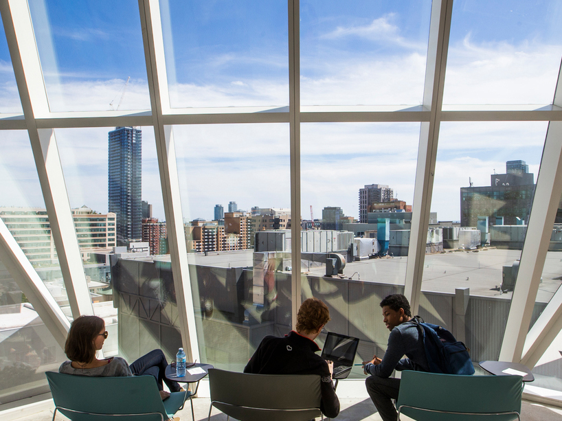 Students sitting on chairs looking out a window.