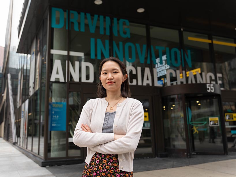 Somin Park in a white cardigan outside of the Ted Rogers School of Management. 