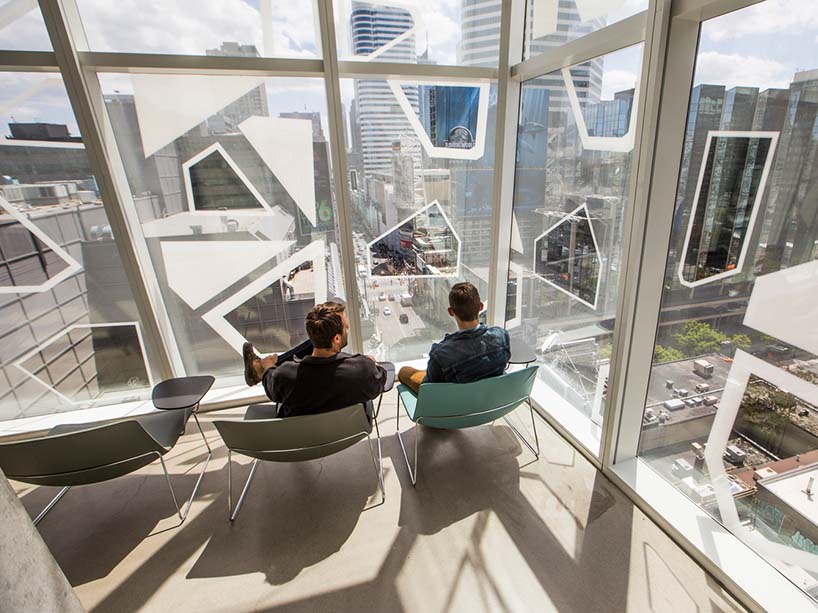 Two students sitting in the SLC and looking out a window