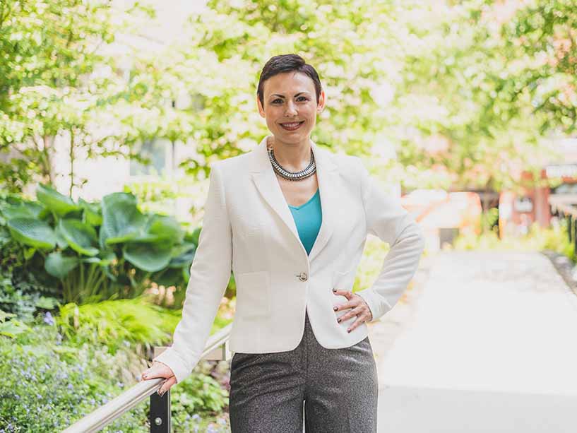 Oksana Romanov in a white blazer and blue shirt. 