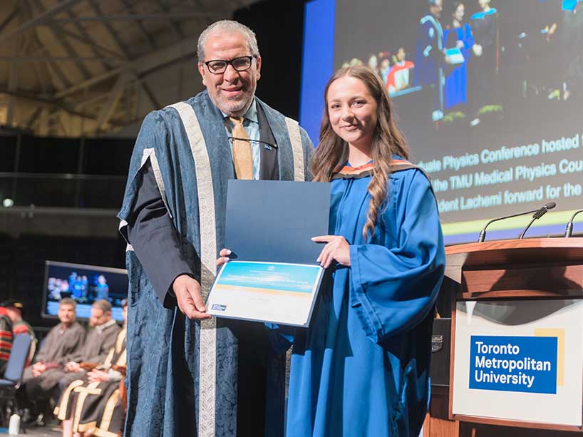 Helen Melino accepts her Gold Medal Award from President Mohamed Lachemi on stage at convocation.