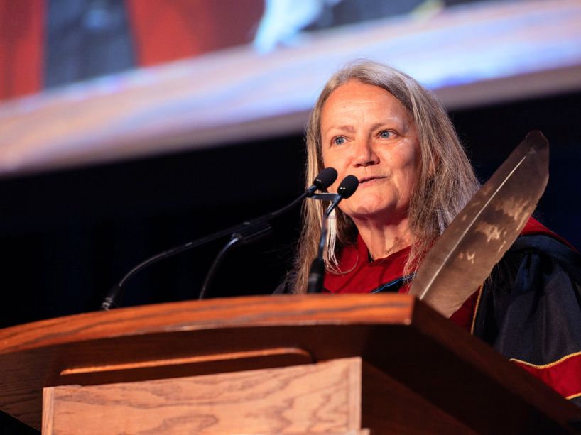 Kimberly Murray, wearing a red and black gown, delivers the Convocation Address.  Photo credit: Kenya-Jade Pinto.