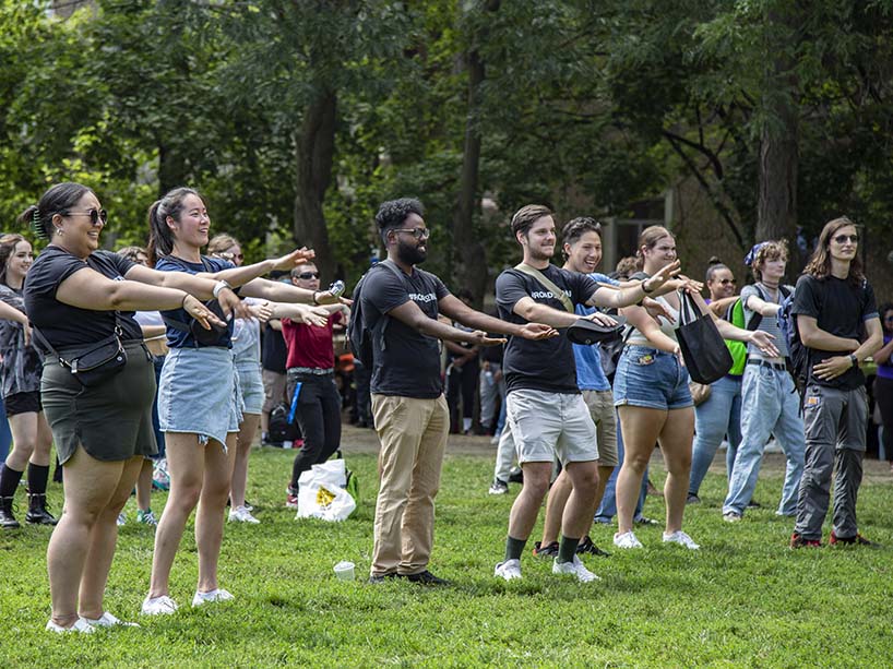 Students with their hands held out on a field. 