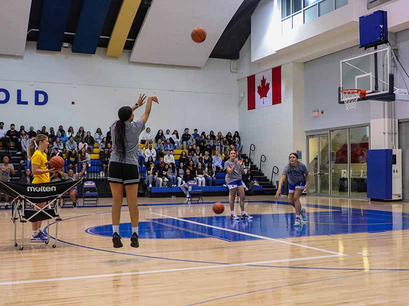 Woman shooting a basketball into the net. 