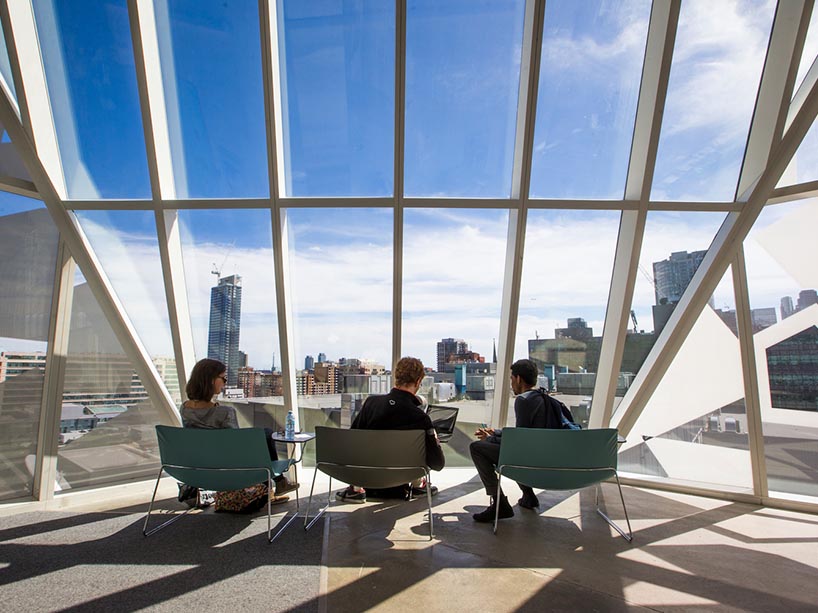 Three people discussing ideas overlooking downtown Toronto.