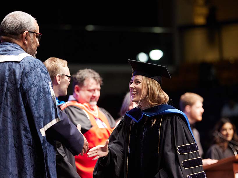 Environmental Applied Science and Management (EnSciMan) PhD student Elissa Penfound smiles as she accepts her Gold Medal award from President Lachemi at Fall 2023 convocation.