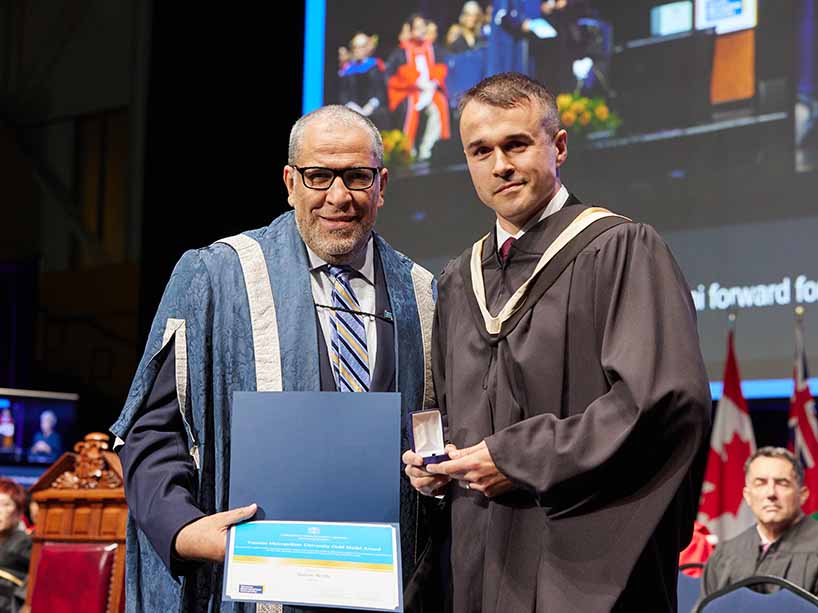 Gold Medal winner Simon Wells, right, a graduate of the MBA program at the Ted Rogers School of Management, accepts his Gold Medal from TMU President Mohamed Lachemi.