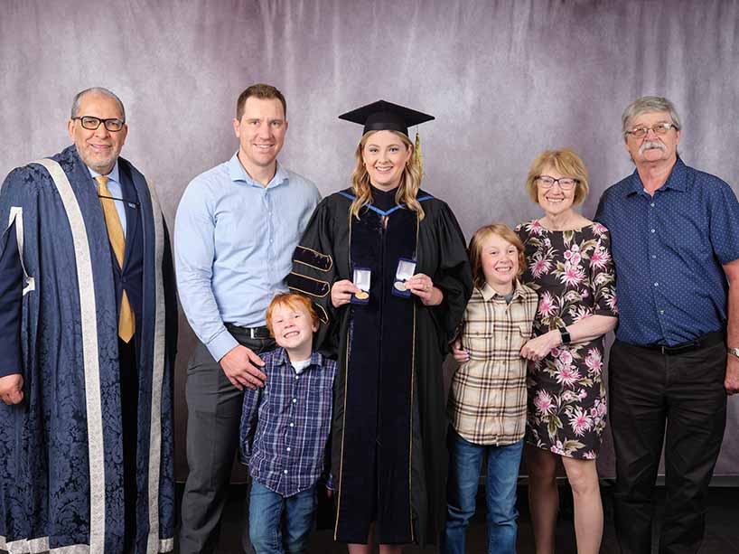 Katey Park, a PhD graduate in psychology, recipient of the TMU Gold Medal and the Board of Governors Leadership Award, is pictured above with her awards, surrounded by her family.