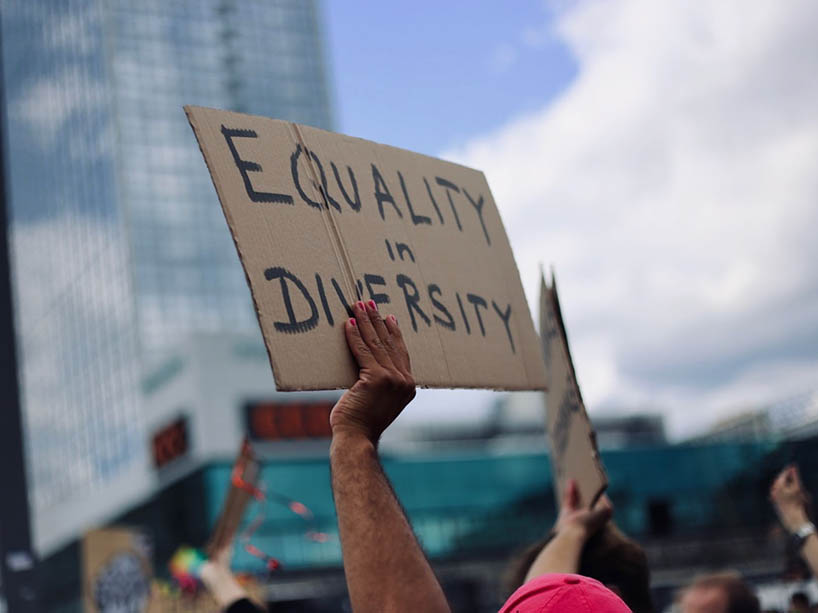 A protestor holds up a sign that says “equality in diversity.”