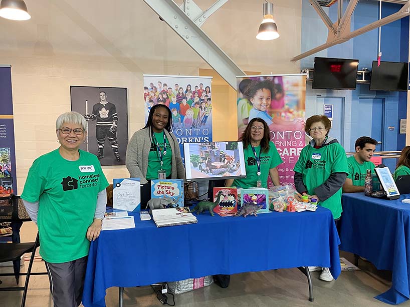 Four people stand around a display table of children’s toys.