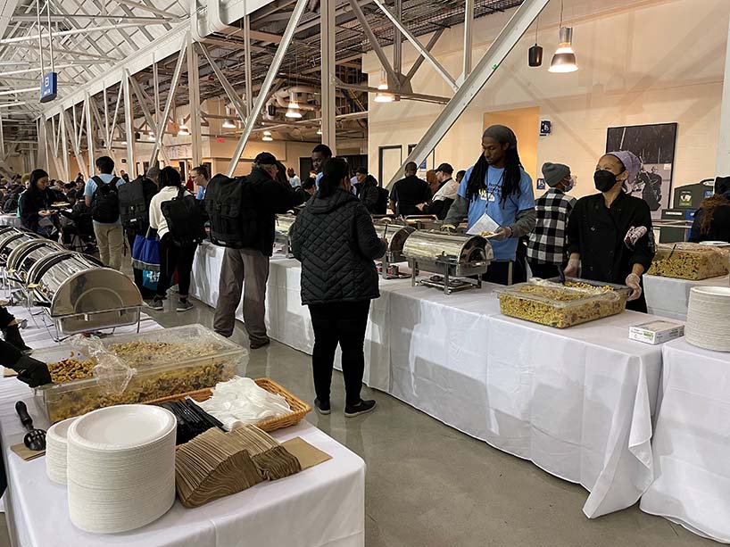 People serve and line up for a buffet.