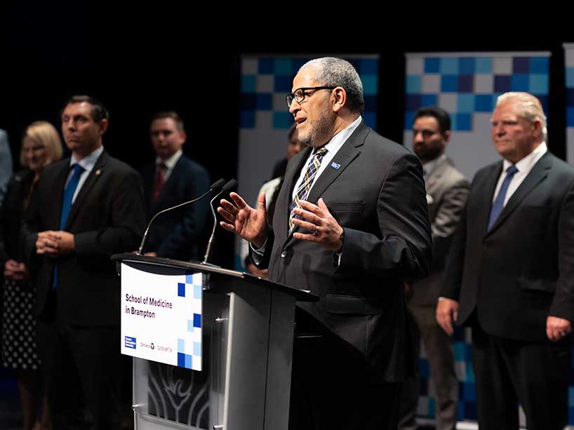 Men standing at a podium behind a mic.