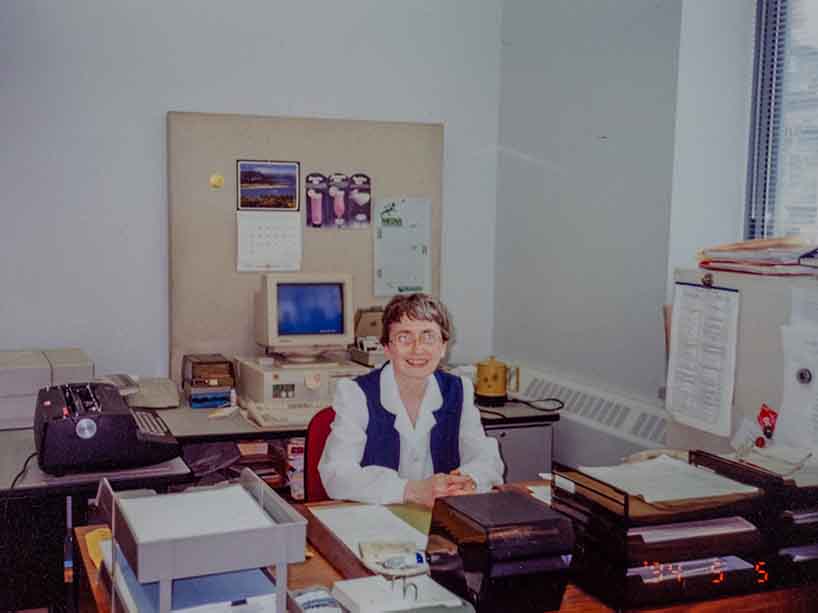 Audrey Bowes smiles from behind her desk.