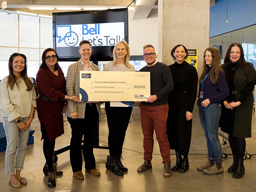 A group of people holding a large, ceremonial cheque. 