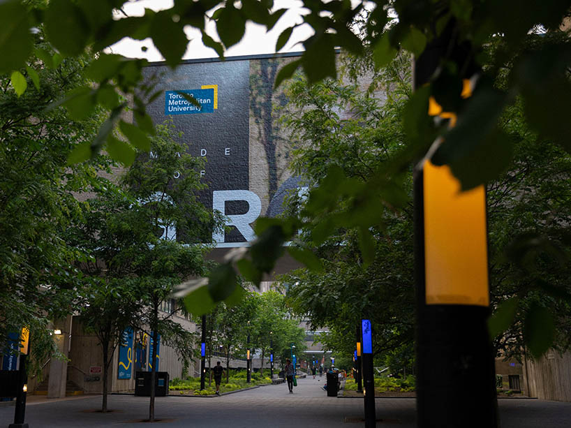 LED street light poles on Gould and Victoria streets lit up in TMU colours - blue and gold.