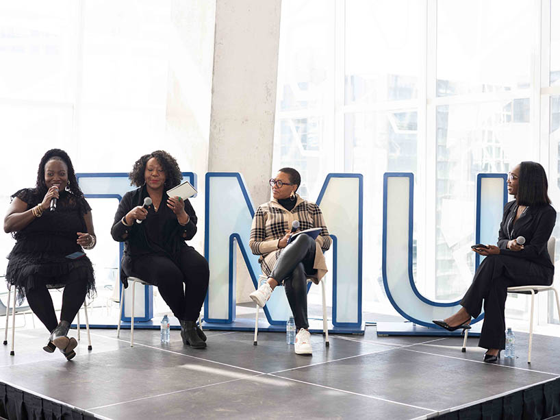 Four Black women engaged in a panel discussion.