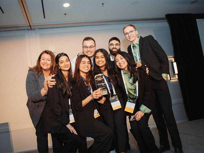A group of people posing with their award for a photo.