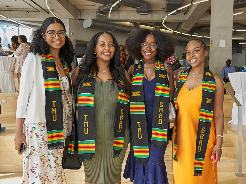 Four Black graduating students wearing Kente stoles at the celebration.