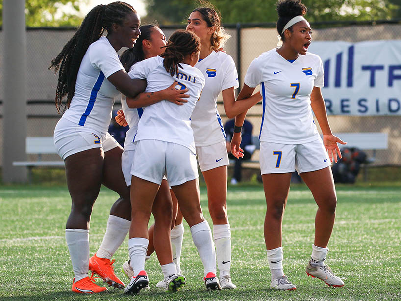 Players of the TMU Bold women’s soccer team celebrate on the field at a game last season.