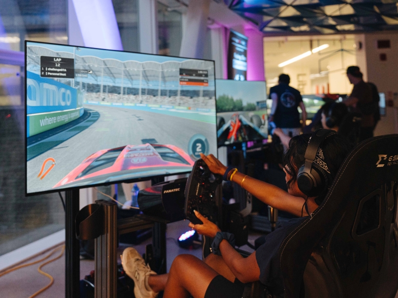 A student plays a race car driving video game.