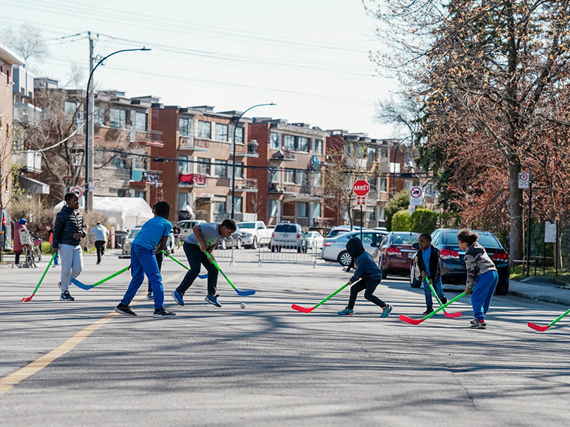 Children play hockey on a neighbourhood street that is closed to cars.