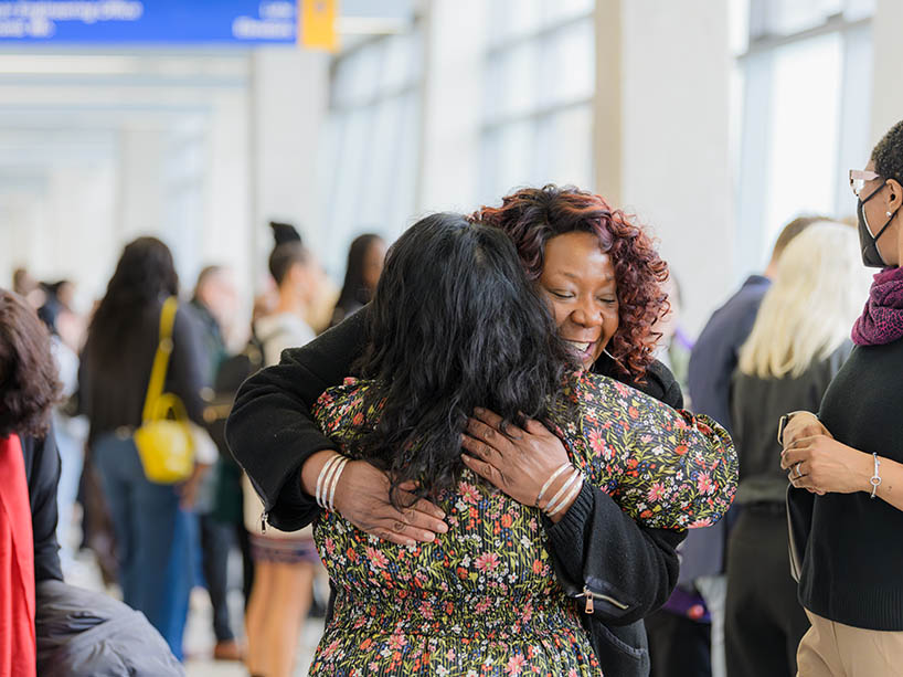 Two women hugging one another.