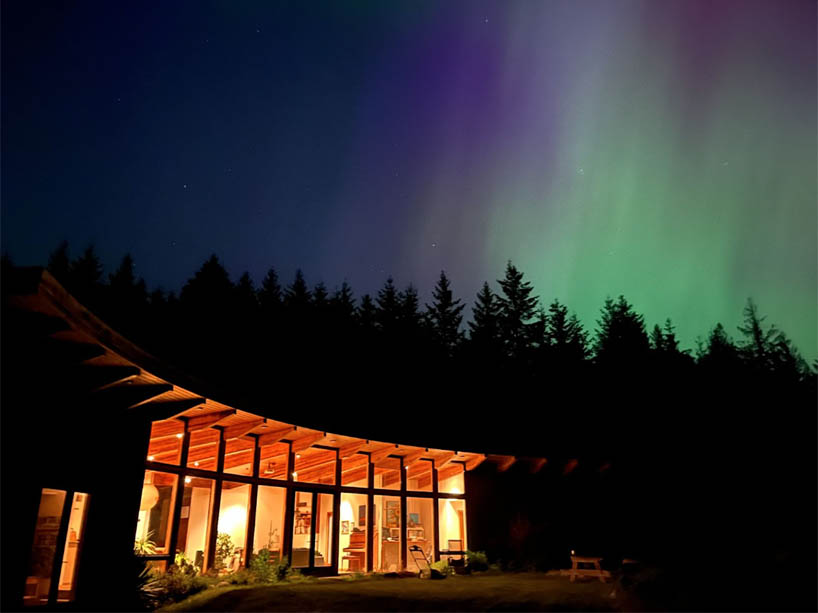 A cabin with the northern lights in the sky.