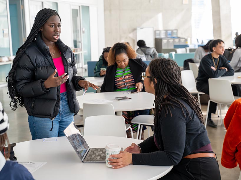 Two Black community members having a conversation at the SLC.