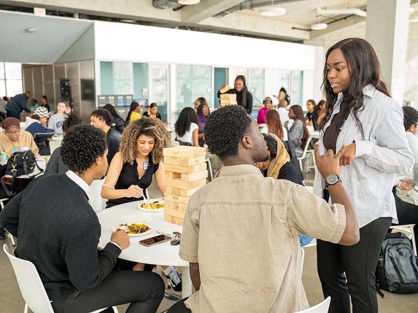 Black students socializing at a table at the Black Excellence Mixer.