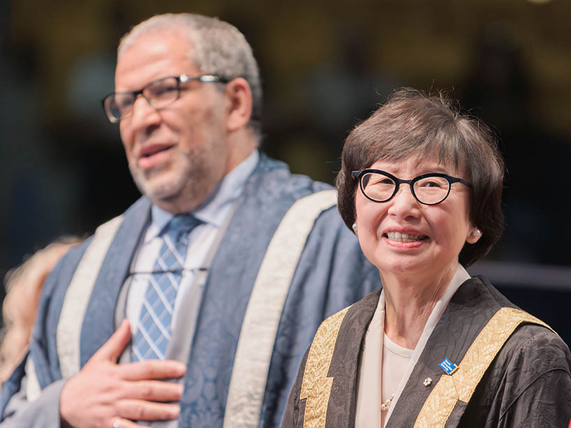 Chancellor Fukakusa on the convocation stage with President Mohamed Lachemi, smiling. 