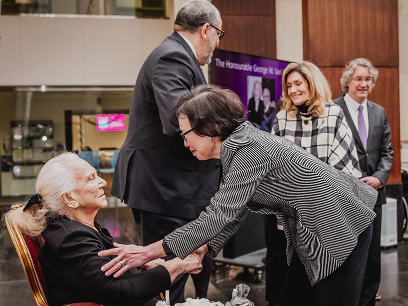 Chancellor Fukakusa shakes hands with Helen Vari and smiling. 