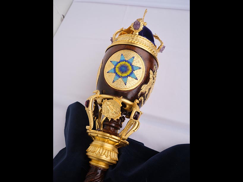 The top portion of TMU’s ceremonial mace, which features a beaded, eight-point star. The star is made of blue and yellow beads and is surrounded by a gold circle.