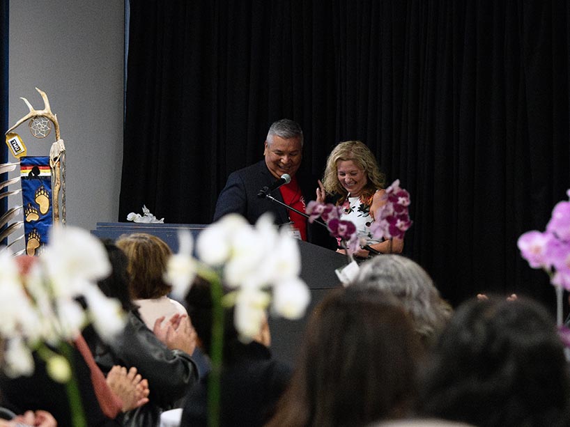 Brian Norton and Roberta Iannacito-Provenzano smile together at the podium.