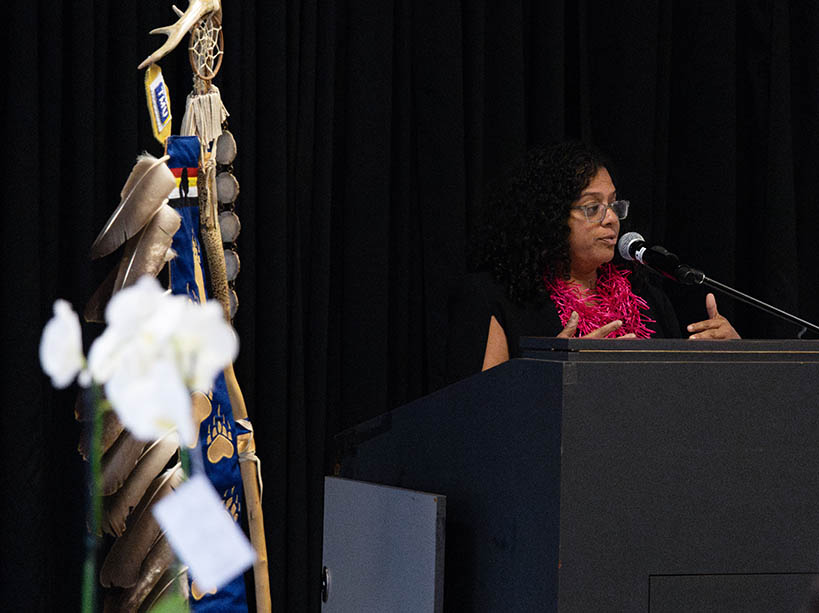 Tanya (Toni) De Mello speaks at the podium.