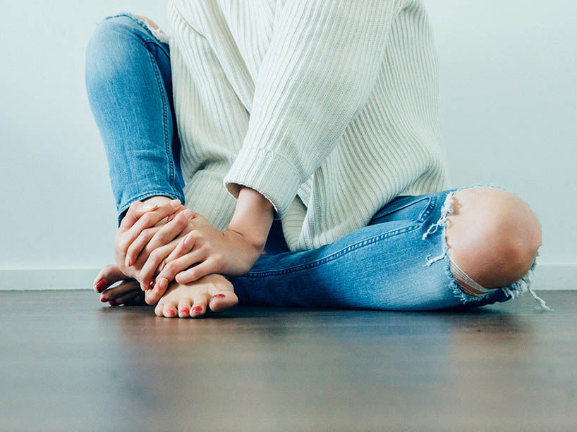 A woman sitting alone on the floor.