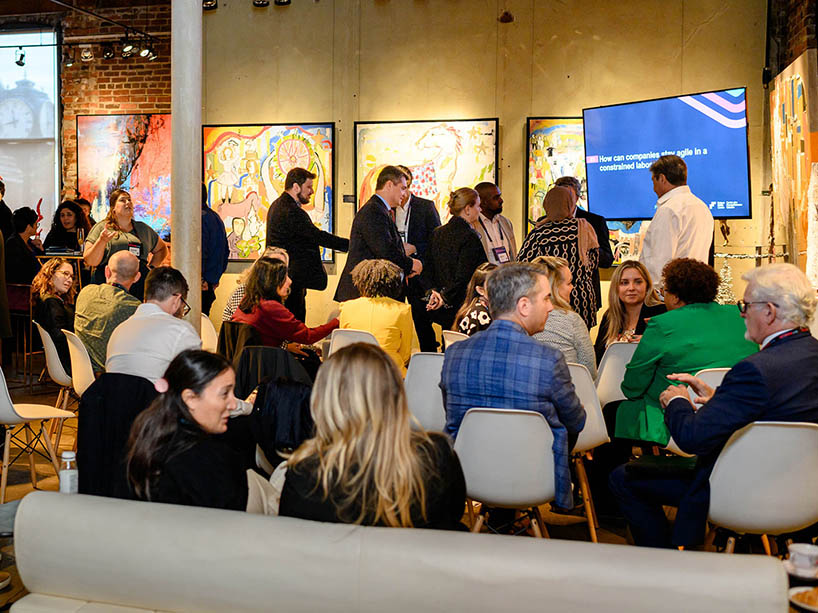 A group of people gather in an event space for networking.