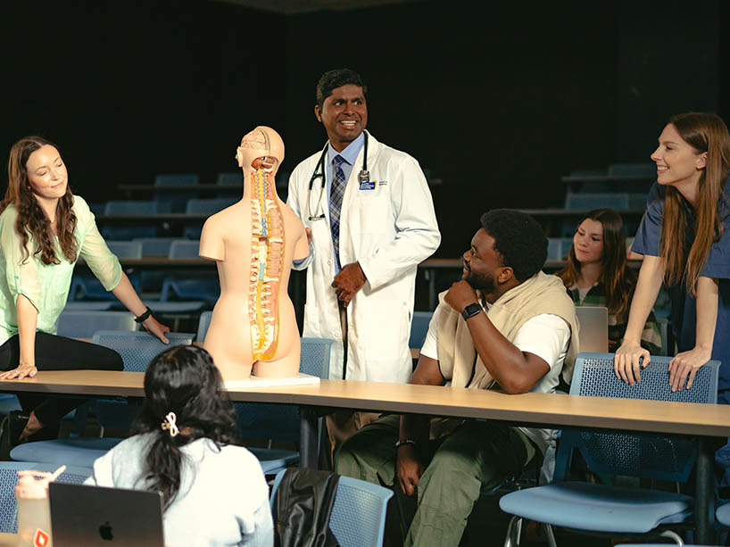 Dr. Nirosshan Thiruchelvam, shown demonstrating an anatomical model to a classroom of students.