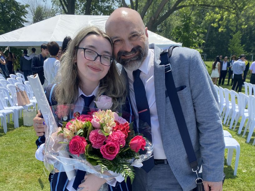 Gen Renaud holding a bouquet of flowers standing next to a man.