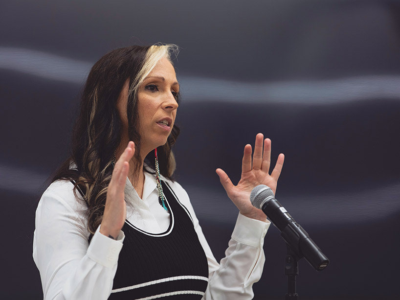 Pamela Palmater speaks into a microphone and gestures with her hands