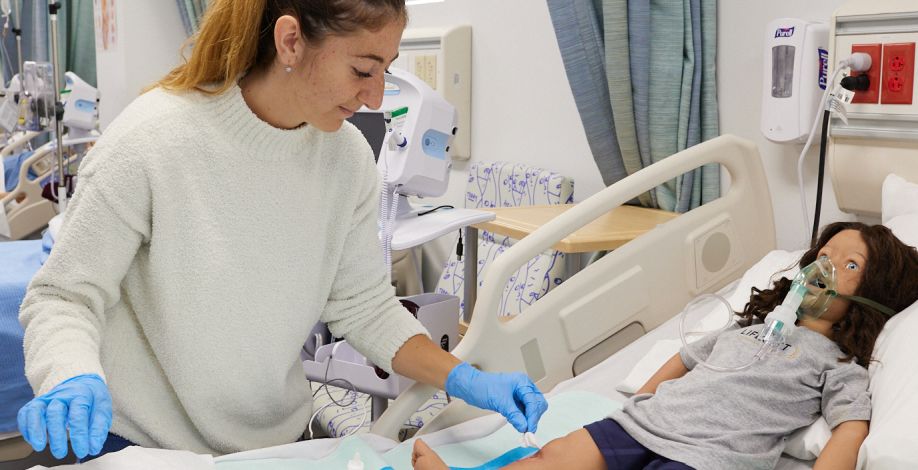 Nursing student attends to a pediatric dummy